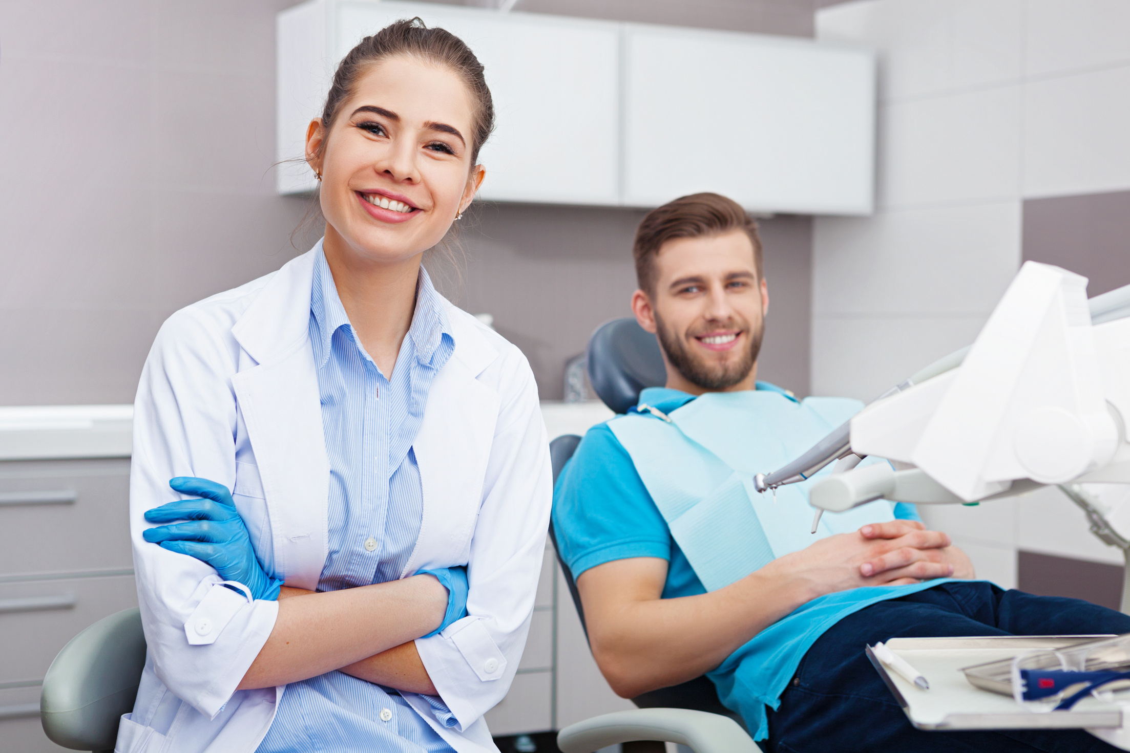 Female dentist and young man in a dentist office.